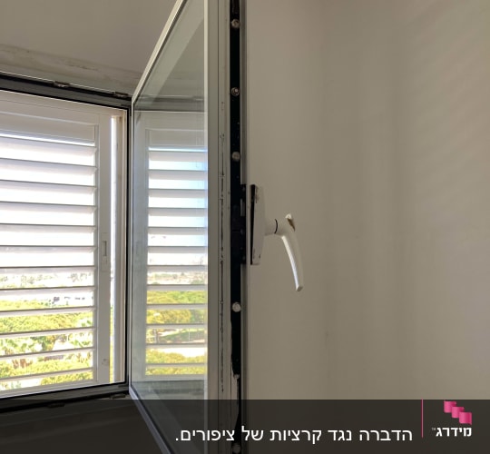 חלון פתוח עם ידית לבנה